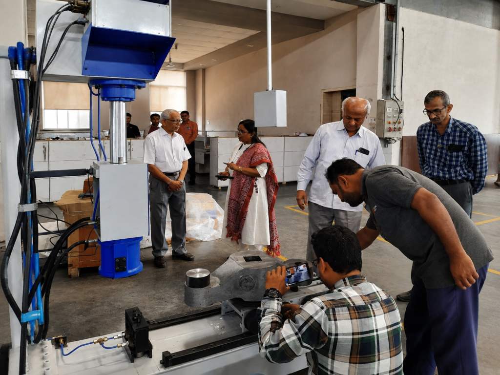 fsa factory machine inspection for indian railways testwin md engineers Directors and engineers from FSA and TESTWIN inspecting a material testing machine at the FSA factory before dispatch for an Indian Railways project.